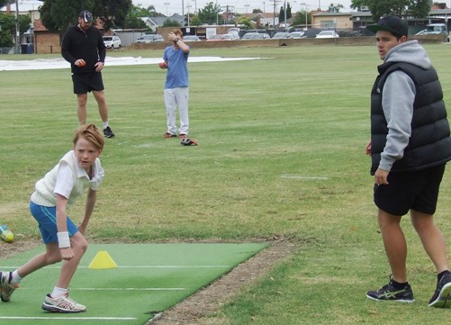 Zac Nilsson shows his slow bowling skills in front of Chris Pollock, as Firsts captain Nate Wolland and Nick Padden look on.