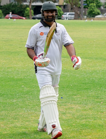Saif Shafqat raises his bat walking off after his unbeaten century.