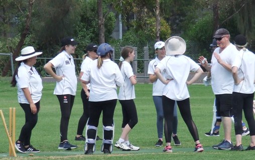 The team gathers around Katherine (middle, white runners) with coach Darren Nagle after the hat-trick ball.