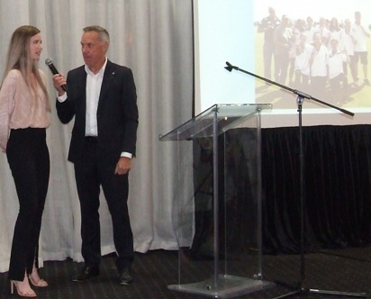 Kelsie Armstrong speaks to MC Ian Coutts - with a photo of the premiership team in the background.