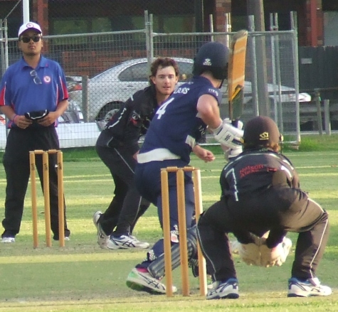 Tain Piercy bowls, with Henry Thomas behind the stumps and Marcus Lee umpiring.