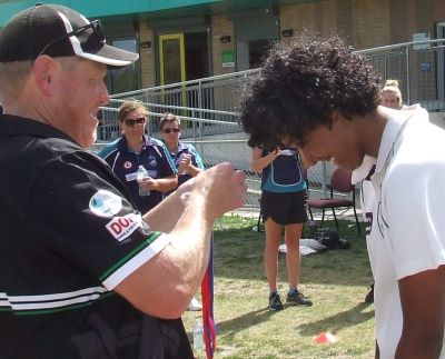 Congratulations: Jane Greenshields gets her Premiership medal from coach Darren Nagle. Jane's two wickets in the 10th over busted the game open.
