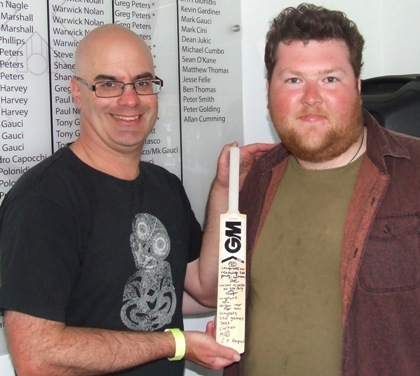 250-gamer Michael Cumbo (left) with teammate Andreas Skiotis and the mini bat signed by the players in his milestone game.