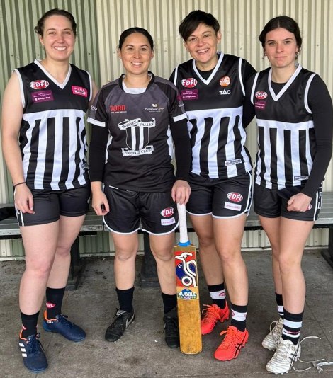 Showing their cricket allegiance with the bat - L-R Sarah Fenn, Yasmin King, Kylie Russo and Maddie Dutton Johnson.